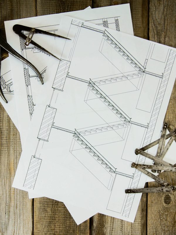 House construction. Many drawings for building and old working tools on old wooden background.